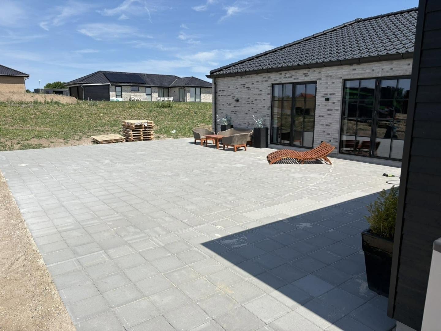 Nyanlagt flisebelægning ved carport og terrasse
